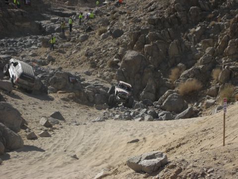 1996 Ford Bronco - Off-road vehicles tackle a challenging course with spectators watching from the rocky hillsides.