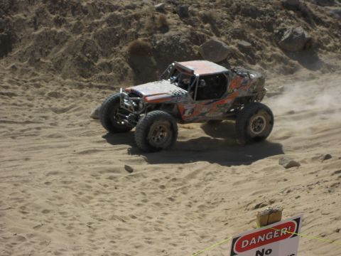 1996 Ford Bronco - Custom off-road buggy navigates a dusty desert course, with a Supermotors.net logo in the foreground.
