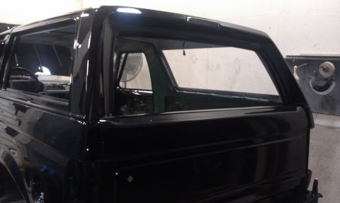 1995 Ford Bronco - The rear section of a black SUV is shown, appearing to be undergoing some form of restoration or repair.