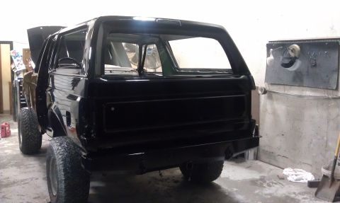 1995 Ford Bronco - This black SUV is undergoing some work in a garage, with its hood up and interior visible.