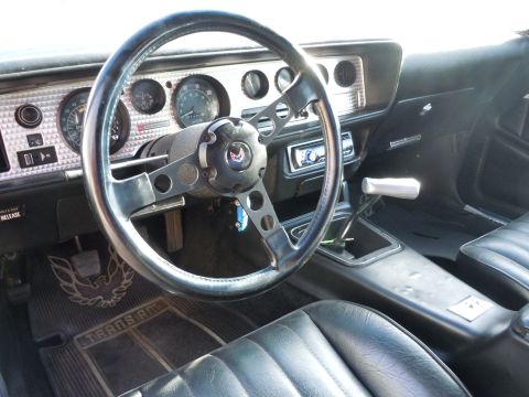 1982 Chevrolet Camaro - The interior of a 1977 Pontiac Trans Am, identifiable by the 'Trans Am' floor mats and dashboard design.