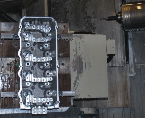1969 Ford Fairlane - A machined engine cylinder head is shown in a workshop setting, with industrial equipment nearby.