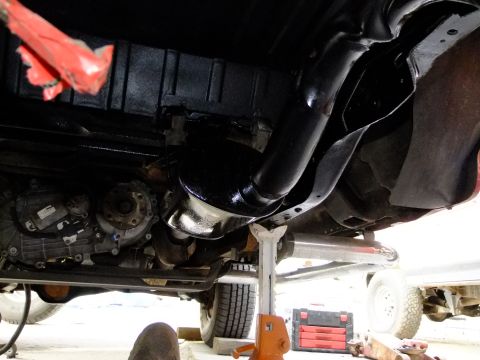 1995 Ford Bronco - The underside of a vehicle is shown, supported by jack stands, with a red toolbox nearby.