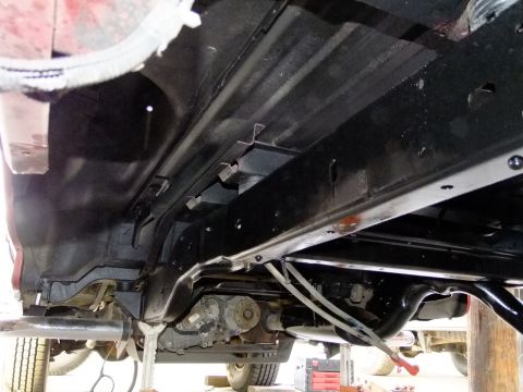 1995 Ford Bronco - The undercarriage of a vehicle is shown, with focus on the rear axle and exhaust system.