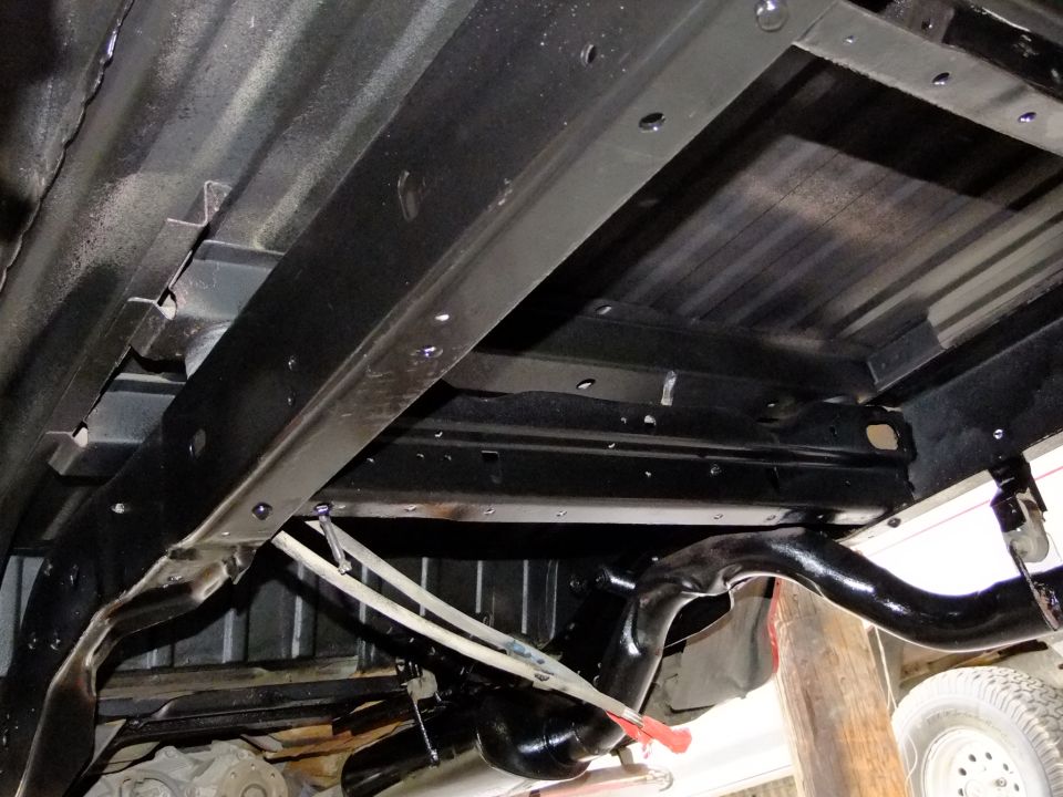 Undercarriage of a vehicle with black painted frame rails and suspension components