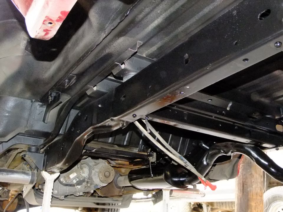 Underbody view of vehicle chassis, exhaust, and transfer case