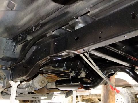 1995 Ford Bronco - The underside of a vehicle, likely a 1990s Ford Bronco, is shown with its frame and exhaust system.