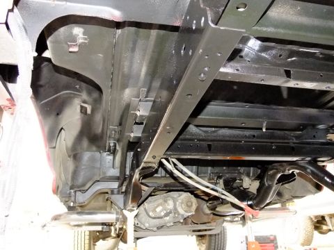 1995 Ford Bronco - The undercarriage of a vehicle is shown, with focus on the chassis and drivetrain components.