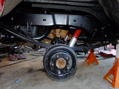 1995 Ford Bronco - Underside view of a vehicle's rear axle and suspension system, supported by jack stands.