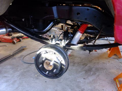 1995 Ford Bronco - The rear chassis and suspension of a vehicle are visible, with a focus on the axle and leaf springs.