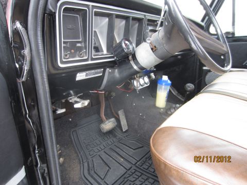 1979 Ford Bronco - Interior view of a vehicle, showing the dashboard, steering wheel, and seats, with a shaker bottle visible.