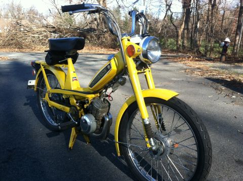 1981 Garelli Rally Sport - A yellow moped is parked on an asphalt road with trees in the background.