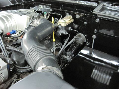 1975 Ford Bronco - Close-up view of the engine bay, focusing on the air intake system and brake fluid reservoir.