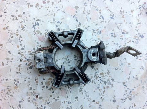 1998 Ford Crown Victoria - Starter brush holder assembly with springs and braided wire on a speckled surface.