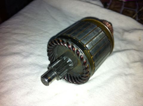 1998 Ford Crown Victoria - A close-up view of a starter motor armature, showing its intricate copper windings and geared shaft.