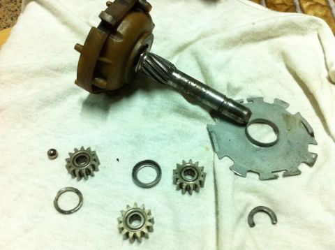 1998 Ford Crown Victoria - Various parts of a starter motor are spread out on a white cloth, suggesting a repair or disassembly process.