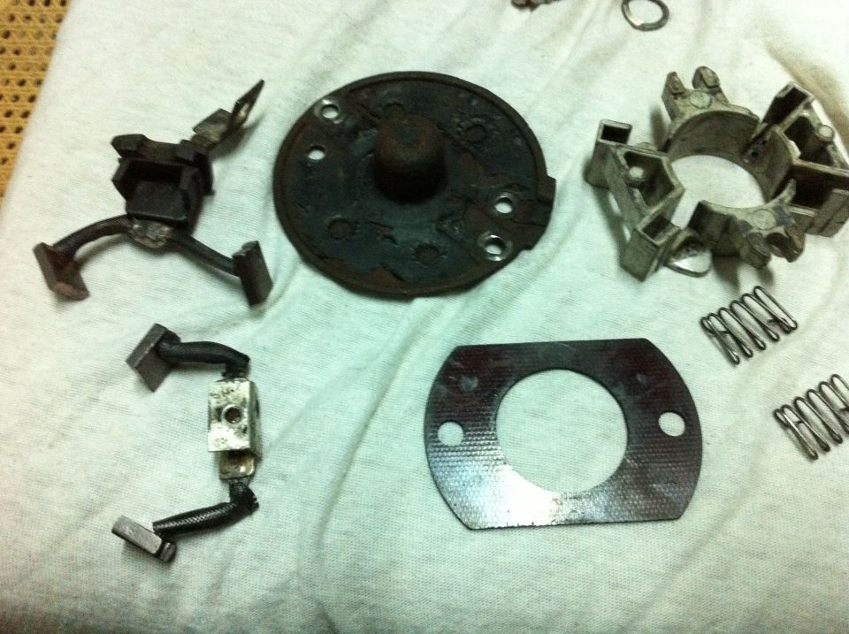 Disassembled starter components including brushes, plate, and springs