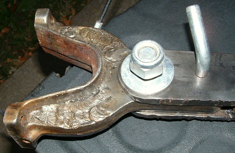 Underside view of a transfer case and dirt-caked driveline with hoses and wiring
