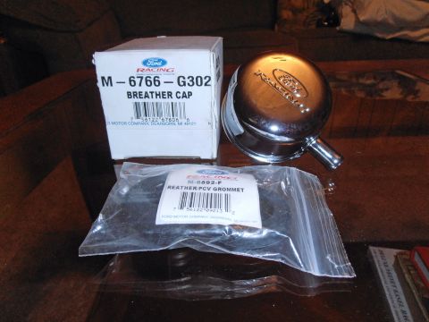 1990 Ford Bronco - Ford Racing breather cap and PCV grommet parts are displayed on a table.
