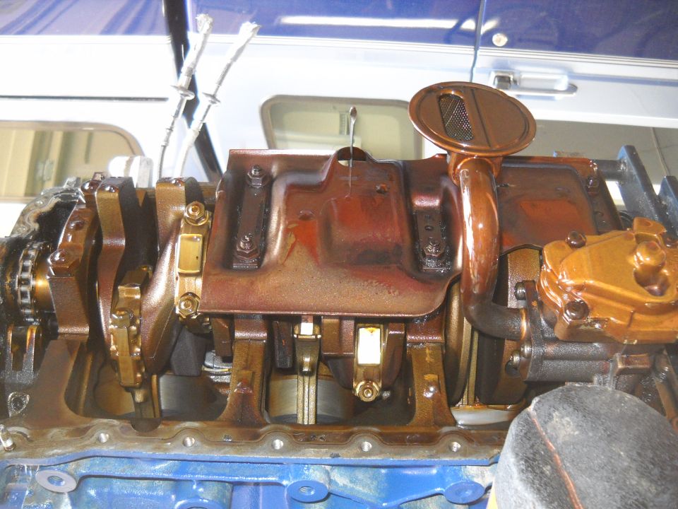 Close-up of an engine's oil pan and crankshaft assembly, showing internal components
