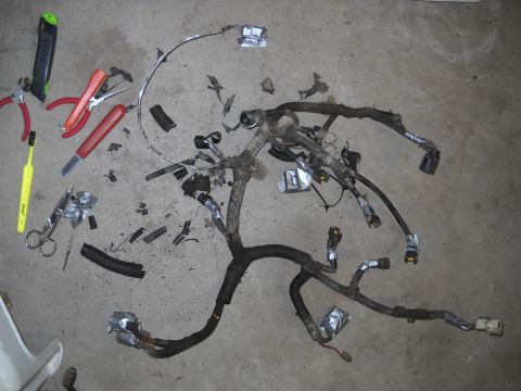 1992 Ford Explorer - A disassembled vehicle wiring harness lies on a concrete surface alongside various tools.