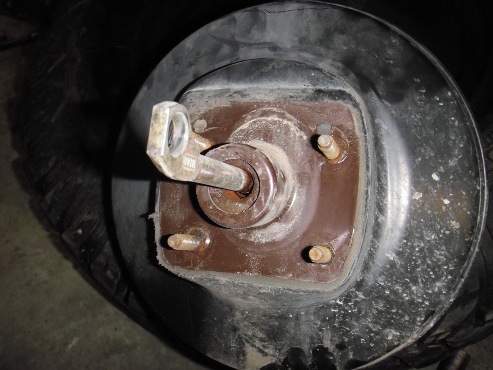 Close-up of a vehicle's brake drum assembly with a lug nut and studs visible