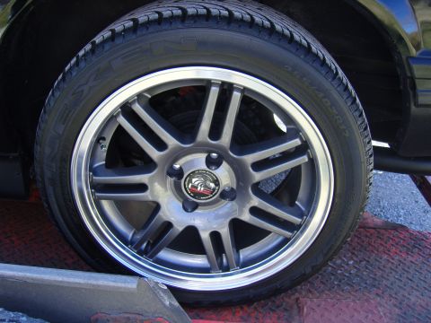 2007 Ford Mustang - A close-up view of a car's wheel and tire, with visible text on the tire's sidewall.