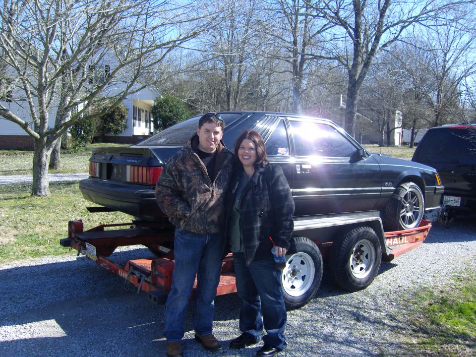 Black 1987 Ford Mustang coupe on trailer, 3q front view