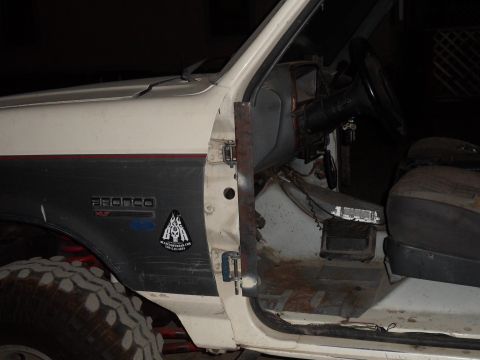 1991 Ford Bronco - The interior of a 1991 Ford Bronco is visible, with the door open to reveal the dashboard and driver's seat.