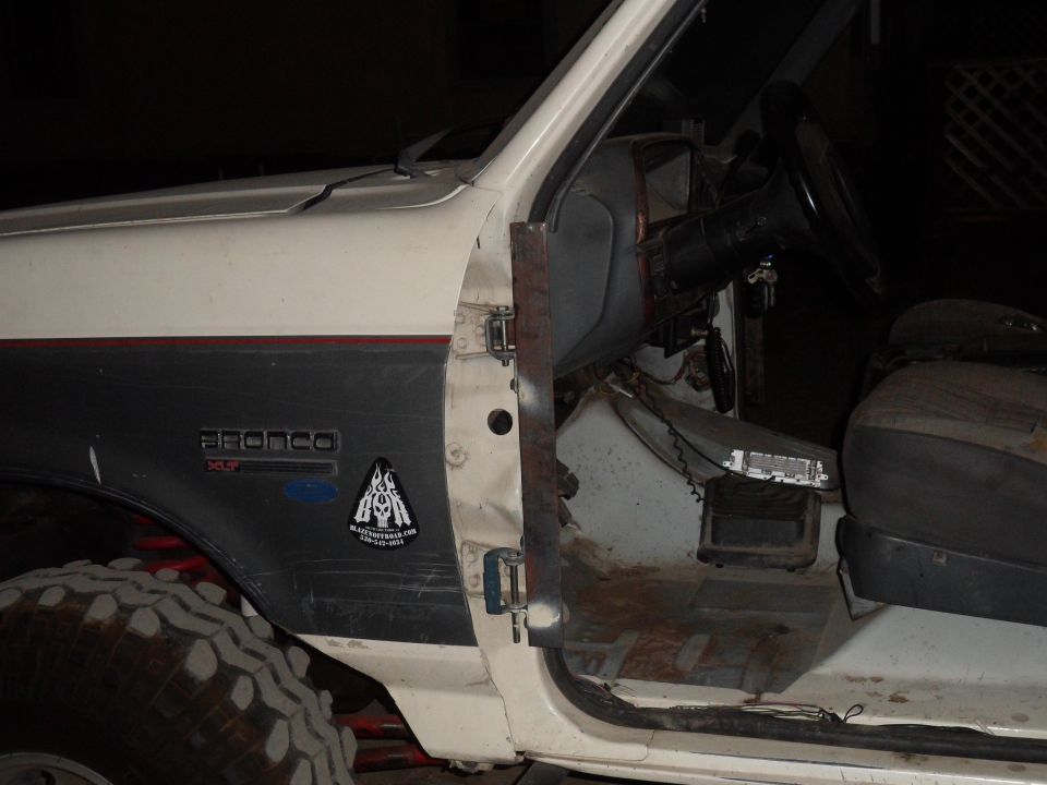 White 1991 Ford Bronco interior, showing door panel with 'BRONCO' badge and steering wheel