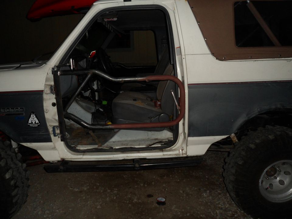 1991 Ford Bronco interior showing roll cage and open driver's door