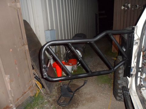 1991 Ford Bronco - A custom door cage is mounted to the side of a white vehicle, with a garage door in the background.