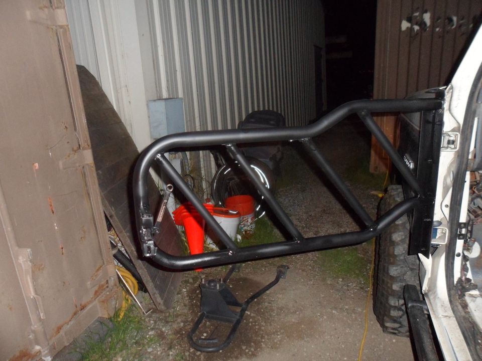White vehicle door frame with black tube cage attached, parked outdoors