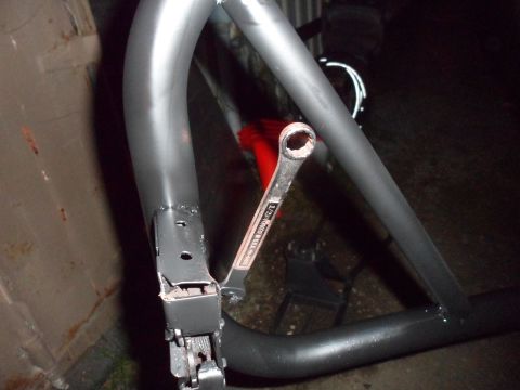 1991 Ford Bronco - A wrench is resting on a metal tube, part of what appears to be a vehicle's roll cage.