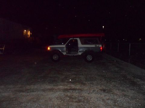 1991 Ford Bronco - This 1991 Ford Bronco is parked at night with its doors open and a red kayak secured to the roof rack.