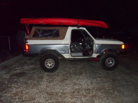1991 Ford Bronco - This 1991 Ford Bronco is equipped with a roof rack carrying a red kayak.