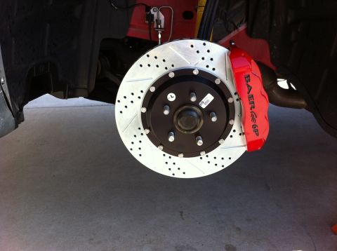 2010 Dodge Challenger - Close-up of a red Baer 6P brake caliper and a drilled rotor, indicating an upgraded braking system.