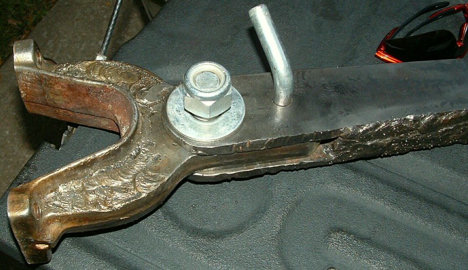 Welded forked steering bracket with bolt and cotter pin, sunglasses in the background