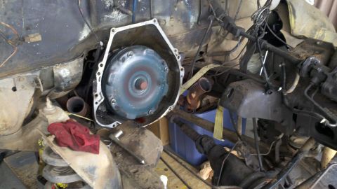 1978 Ford Bronco - The torque converter is visible, detached from the transmission housing, during a motor rebuild.