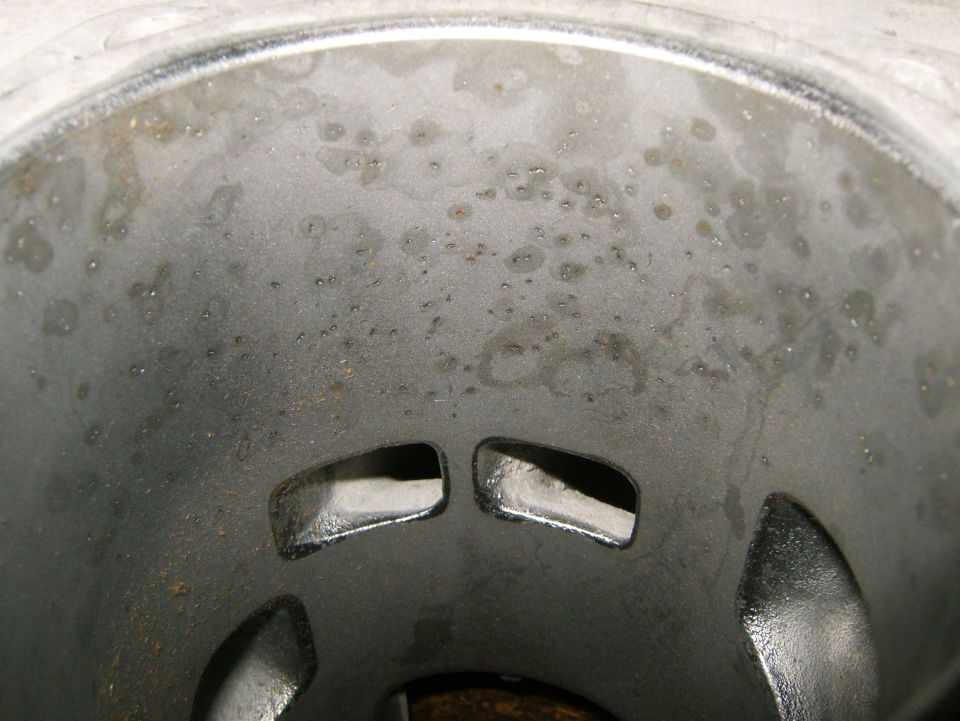 Inside of an engine cylinder bore with some pitting and two rectangular ports visible