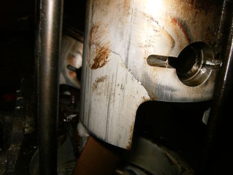 2000 Ford E350 - Close-up view of a damaged piston, showing a significant crack and wear marks.