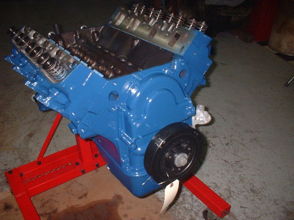 Blue engine on a red stand, front pulley visible with a tag