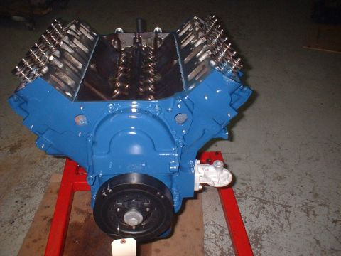 1969 Mercury Cyclone - A blue V8 engine with chrome valve covers is displayed on a red engine stand.