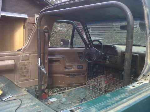 1990 Ford Bronco - Custom roll cage installed in the interior of a 1990 Ford Bronco, showing the dashboard and door panels.
