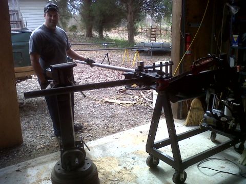 1990 Ford Bronco - Man uses a pipe bender in a garage workshop.