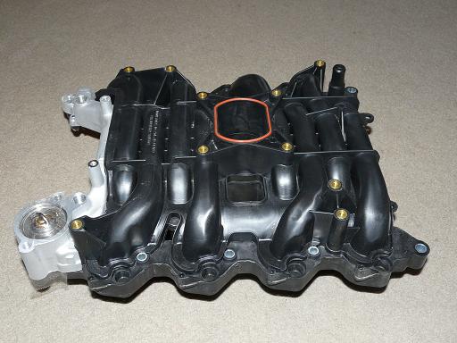 Ford intake manifold with visible part numbers and a red gasket ring