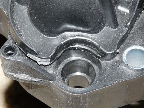 1999 Ford Crown Victoria - Close-up of a damaged plastic intake manifold part, showing cracks and wear.