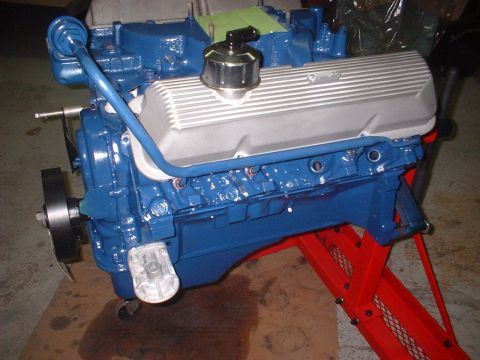 1969 Mercury Cyclone - A freshly painted blue V8 engine is mounted on a red engine stand, ready for installation.