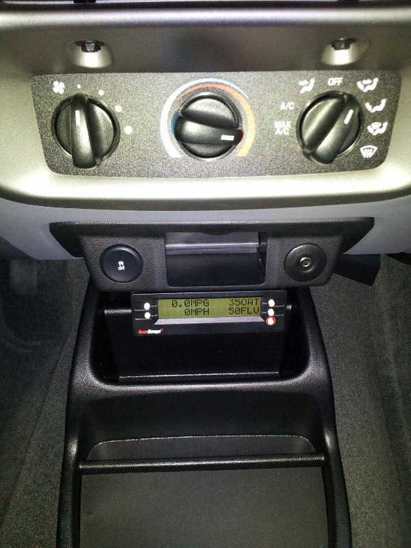 Interior dashboard with climate controls and a digital gauge displaying MPG and MPH