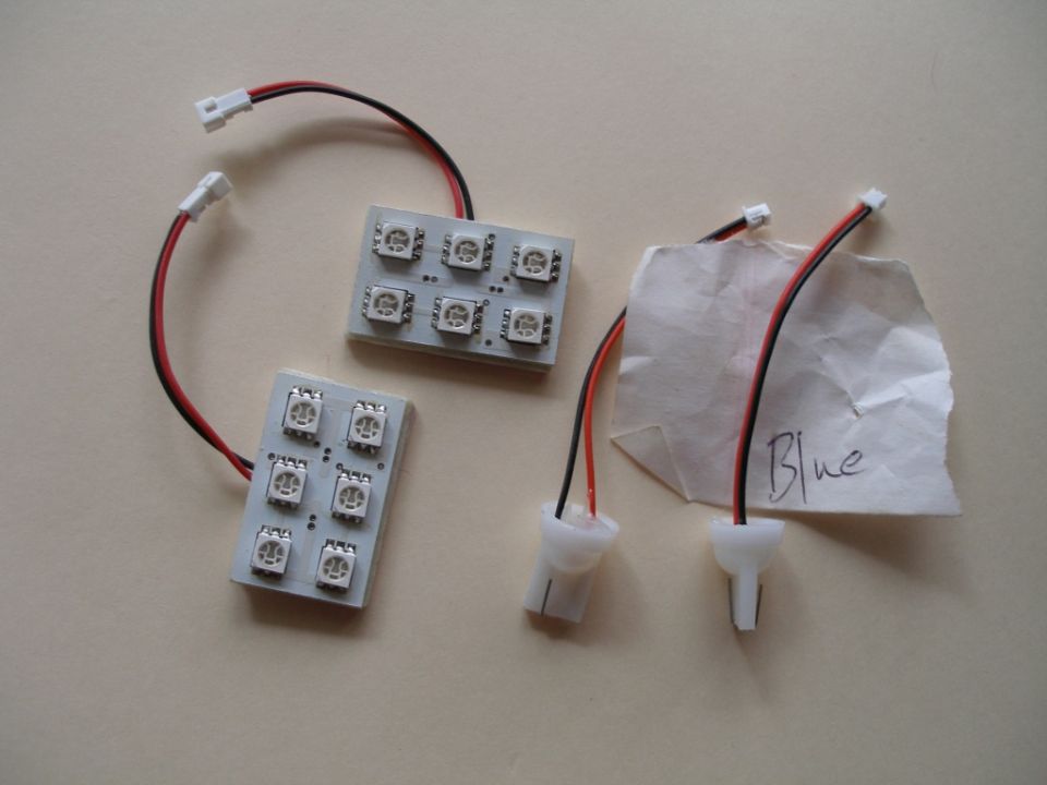 Two circuit boards with multiple LEDs and wires. One has a piece of paper taped to it with 'Blue' written on it